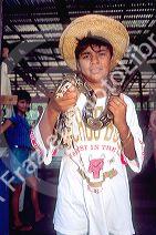 Brazillian indian boy holding pet python snake around his neck in Manaus Brazil.