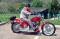 Man riding a Harley Davidson motorcycle with proper safety gear.