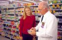 Pharmacist showing customer cold medicine in a drug store. MR