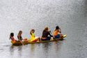 Brazilian girls riding in a canoe on the Arasa River in the Amazon jungle near Manaus, Brazil.