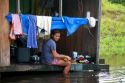 Brazilian girl washing clothes in the Arasa River in the Amazon jungle near Manaus, Brazil.