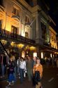 People on the street in front of the Royal Carre Theatre at night in Amsterdam, Netherlands.