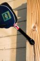 A cats paw crowbar pulling a nail out of a piece of wood.