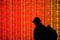 Man walking past a glass block wall lit with red light at Washington Dulles International Airport, Washington D.C.