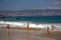 Beach scene in Renaca on the Pacific Ocean in Chile with Vina del Mar and Valparaiso in the background.