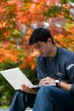 Male student studying with a laptop computer in Harvard Yard at Harvard University in Cambridge, Greater Boston, Massachusetts, USA. MR
