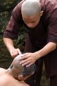 Novice Buddhist monks shave each other's heads at the Thien Mu Pagoda along the Perfume River in Hue, Vietnam.