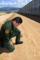 United States Border Patrol agent checking for footprints at the U.S./Mexico border near San Diego, California.