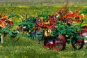 Colorfully painted antique plows on display at a farm near Corunna, Michigan, USA.