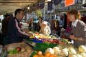 People shopping for produce at an outdoor Saturday market in Paris, France.
