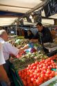 People shopping for produce at an outdoor Saturday market in Paris, France.