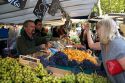 People shopping for produce at an outdoor Saturday market in Paris, France.
