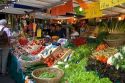 People shopping for produce at an outdoor Saturday market in Paris, France.