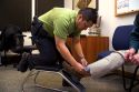 Law enforcement agent attaching an ankle monitor to a criminal under house arrest.