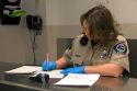 Booking agent taking inventory of an inmates personal property in a jail.