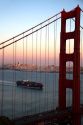 Container ship and the Golden Gate Bridge at dusk in the San Francisco Bay area, California, USA.