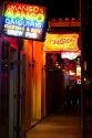 Neon signs of bars and restaurants along Bourbon Street in the French Quarter of New Orleans, Louisiana, USA.
