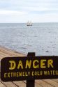 Danger sign warning of extremely cold water at the Grand Portage National Monument on the north shore of Lake Superior in northeastern Minnesota, USA.